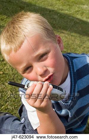 Picture - 4 year old boy talking into a walkie-talkie, looking into camera. Fotosearch