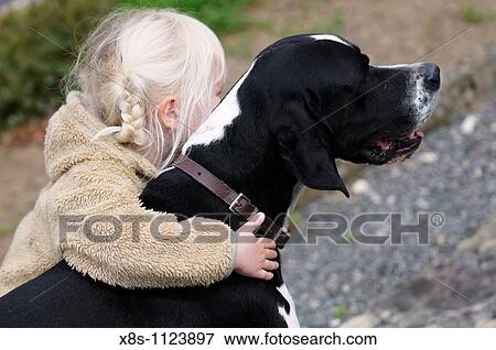 Stock Photo - 4 year old child hugging her pet dog. Fotosearch