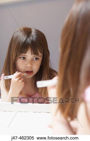 4 year old girl applying lipgloss in a mirror View Large Photo Image Stock Photography - 4 year old girl applying lipgloss in a mirror. Fotosearch