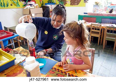 4 year old girl at nursery, sitting with the teacher doing messy play View Large Photo Image Stock Image - 4 year old girl at nursery, sitting with the teacher doing messy play. Fotosearch