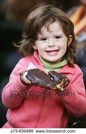 4 year old girl eating chocolate pastry View Large Photo Image Stock Photo - 4 year old girl eating chocolate pastry. Fotosearch