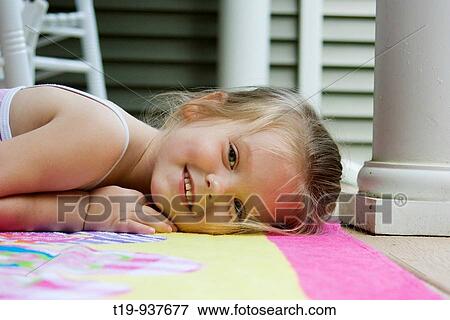 Stock Photo - 4-year old girl enjoying a warm summer afternoon on the front porch of her home MR. Fotosearch