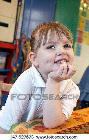 Stock Image - 4 year old girl looking off camera at nursery. Fotosearch