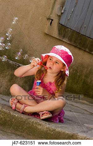 4 year old girl sitting cross legged on a step blowing bubbles in the sunshine View Large Photo Image Stock Image - 4 year old girl sitting cross legged on a step blowing bubbles in the sunshine. Fotosearch
