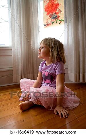 4 year old girl sitting on floor in her house looking off camera in a pink dress and purple shirt View Large Photo Image Stock Photo - 4 year old girl sitting on floor in her house looking off camera in a pink dress and purple shirt. Fotosearch