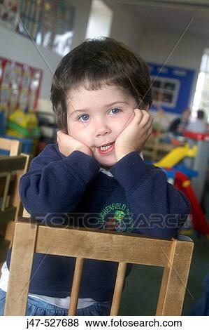 4 year old girl smiling into camera at nursery, with her chin in her hands View Large Photo Image Stock Photo - 4 year old girl smiling into camera at nursery, with her chin in her hands. Fotosearch
