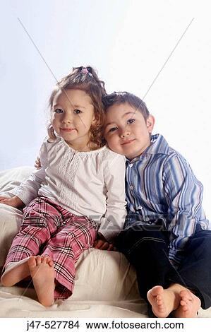 4 year old girl with blonde hair, smiling into camera, in the studio, sitting on the floor, with her older brother View Large Photo Image Picture - 4 year old girl with blonde hair, smiling into camera, in the studio, sitting on the floor, with her older brother. Fotosearch