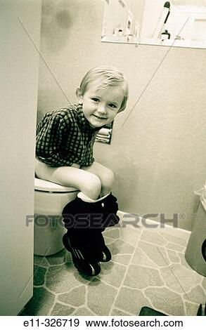 Stock Photo - 4 years old boy sitting on potty. Fotosearch