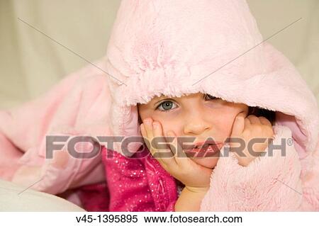 Stock Photography - 4 years old girl in pink clothing lying under the hood.. Fotosearch