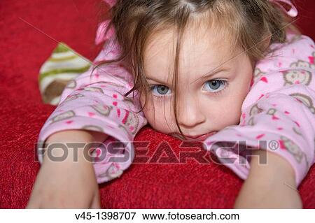 4 years old girl in pink pyjama lying on red sofa bed. View Large Photo Image Stock Photo - 4 years old girl in pink pyjama lying on red sofa bed.. Fotosearch