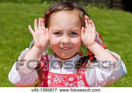 Stock Photo - 4 years old girl in red dress sitting on the grass.. Fotosearch