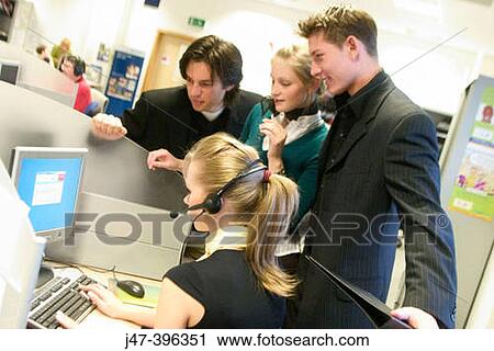 4 young business people standing in a group round a computer at work View Large Photo Image Stock Image - 4 young business people standing in a group round a computer at work. Fotosearch
