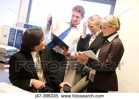 4 young business people standing in a group talking together at work View Large Photo Image Stock Photography - 4 young business people standing in a group talking together at work. Fotosearch