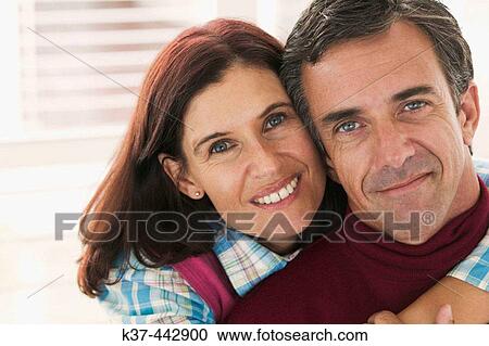 Stock Image - 40-45 year old Caucasian couple relaxing in living room. Fotosearch