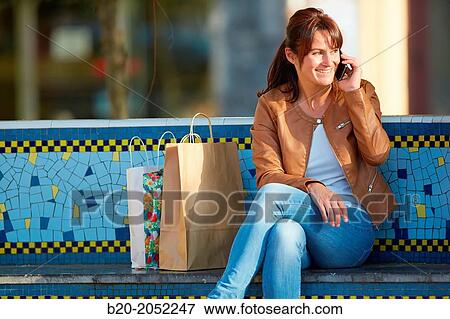 Stock Photo - 40 Woman talking on the phone. Shopping on the street. Donostia. San Sebastian. Gipuzkoa. Basque Country. Spain.. Fotosearch