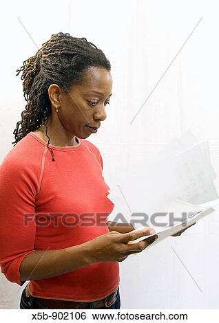 40 year old African American woman with dredlocks in her hair looking over some papers Side view Copyspace Isolated on white Red t-shirt Vertical View Large Photo Image Stock Photograph - 40 year old African American woman with dredlocks in her hair looking over some papers Side view Copyspace Isolated on white Red t-shirt Vertical. Fotosearch