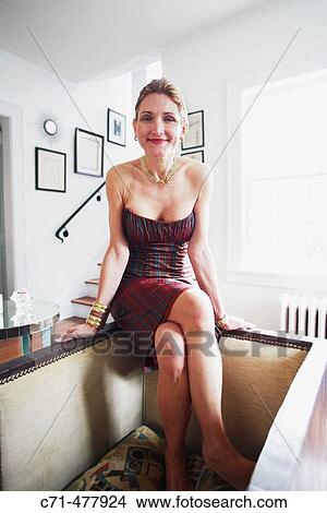 40's sexy elegant caucasian woman smiling in the camera in her living room View Large Photo Image Picture - 40's sexy elegant caucasian woman smiling in the camera in her living room. Fotosearch
