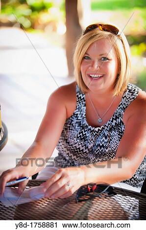 45 years old woman writing a check in outdoor restaurant View Large Photo Image Stock Image - 45 years old woman writing a check in outdoor restaurant. Fotosearch