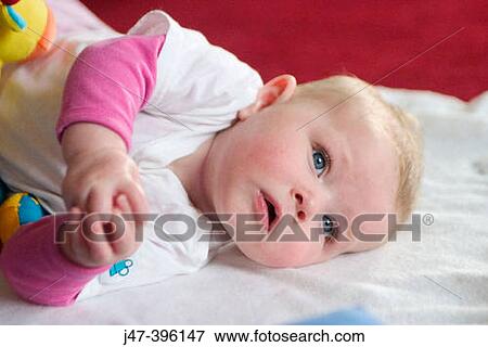 5 month old baby girl lying on side, serious, hands together View Large Photo Image Stock Photo - 5 month old baby girl lying on side, serious, hands together. Fotosearch