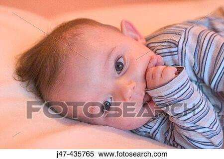 5 month old boy lying down, sucking thumb smiling View Large Photo Image Stock Photography - 5 month old boy lying down, sucking thumb smiling. Fotosearch