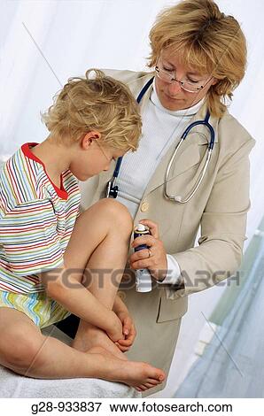 Stock Photo - 5 year old boy and doctor spraying clean a bruise. Fotosearch