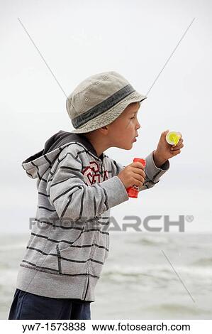 5 year old boy blowing soap bubbles on a beach View Large Photo Image Stock Photo - 5 year old boy blowing soap bubbles on a beach. Fotosearch