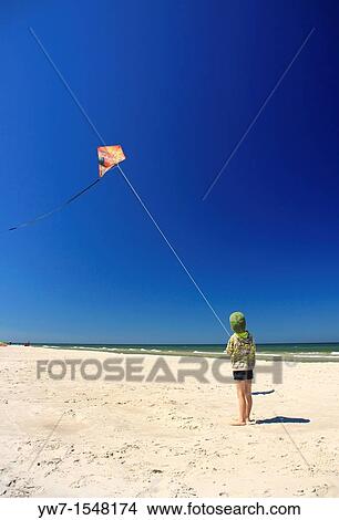 5 year old boy flying his kite on a beach View Large Photo Image Picture - 5 year old boy flying his kite on a beach. Fotosearch