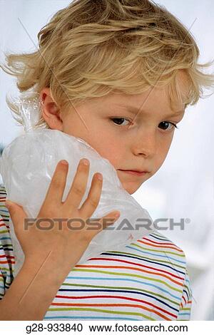 Stock Image - 5 year old boy using ice to prevent bruise and swelling. Fotosearch