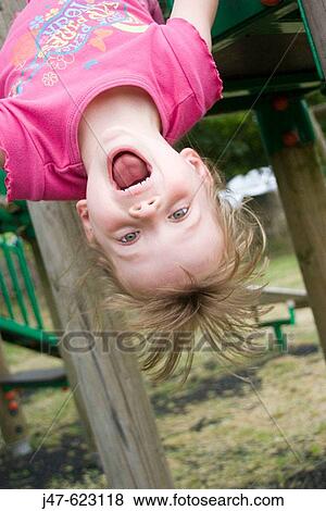 5 year old girl hanging upside down on a climbing frame laughing. View Large Photo Image Stock Photo - 5 year old girl hanging upside down on a climbing frame laughing.. Fotosearch