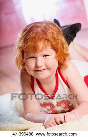 5 year old girl lying on her tummy, smiling into camera View Large Photo Image Stock Photo - 5 year old girl lying on her tummy, smiling into camera. Fotosearch