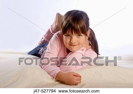 5 year old girl lying on the floor in the studio smiling into camera View Large Photo Image Picture - 5 year old girl lying on the floor in the studio smiling into camera. Fotosearch