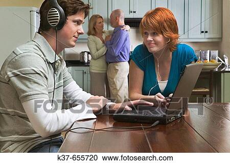 50-60 y/o couple dancing to music from stereo/radio in kitchen with teen/adult children sitting in dining room listening to music on laptop & ipod. View Large Photo Image Stock Image - 50-60 y/o couple dancing to music from stereo/radio in kitchen with teen/adult children sitting in dining room listening to music on laptop & ipod.. Fotosearch