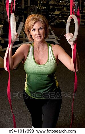 50 year old woman in health club setting working out with equipment smiling to the camera View Large Photo Image Stock Photo - 50 year old woman in health club setting working out with equipment smiling to the camera. Fotosearch