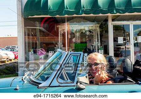 57 year old woman with long hair driving her MG convertible car flipping off the photographer View Large Photo Image Picture - 57 year old woman with long hair driving her MG convertible car flipping off the photographer. Fotosearch