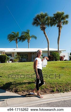 57 year old woman with long hair standing by a mailbox in front of her house in Florida View Large Photo Image Stock Image - 57 year old woman with long hair standing by a mailbox in front of her house in Florida. Fotosearch