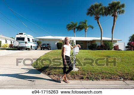 57 year old woman with long hair standing by a mailbox in front of her house in Florida View Large Photo Image Stock Image - 57 year old woman with long hair standing by a mailbox in front of her house in Florida. Fotosearch