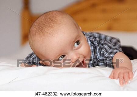 6 month old baby boy lying on his tummy laughing View Large Photo Image Stock Image - 6 month old baby boy lying on his tummy laughing. Fotosearch
