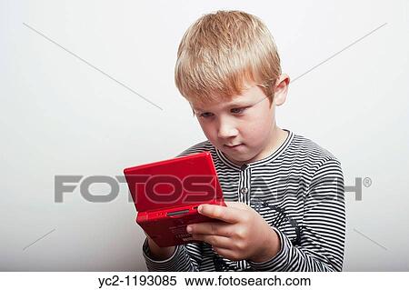 6 year old boy playing with a Nintendo DS handheld games console in the studio View Large Photo Image Stock Photography - 6 year old boy playing with a Nintendo DS handheld games console in the studio. Fotosearch