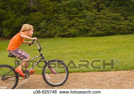 6 year old boy riding a bike very fast. Point Harbor, North Carolina. USA View Large Photo Image Stock Photograph - 6 year old boy riding a bike very fast. Point Harbor, North Carolina. USA. Fotosearch