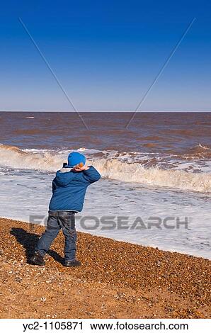 6 year old boy throwing a stone out to sea on a uk beach View Large Photo Image Stock Image - 6 year old boy throwing a stone out to sea on a uk beach. Fotosearch