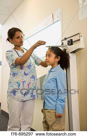 6 Year old girl having her height measurment made by pediatric nurse View Large Photo Image Stock Photo - 6 Year old girl having her height measurment made by pediatric nurse. Fotosearch
