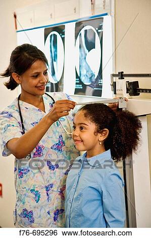 6 Year old girl having her height measurment made by pediatric nurse View Large Photo Image Stock Photograph - 6 Year old girl having her height measurment made by pediatric nurse. Fotosearch