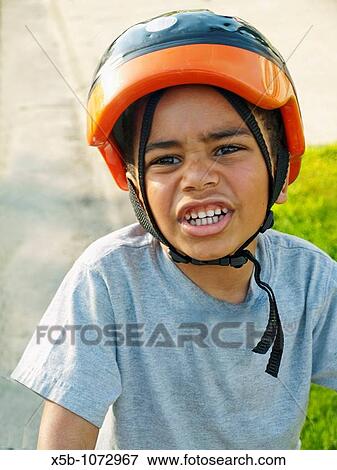 6 year old multiracial boy with bike helmet on Making a funny face View Large Photo Image Stock Photo - 6 year old multiracial boy with bike helmet on Making a funny face. Fotosearch