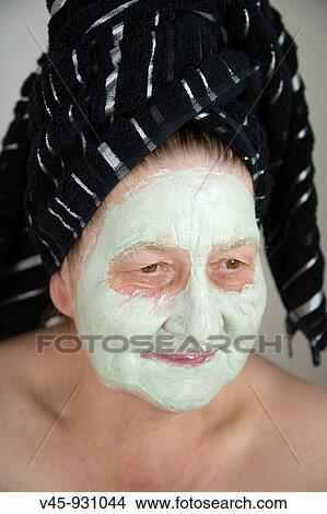 67 years old woman with a towel on her head and green mask on her face View Large Photo Image Picture - 67 years old woman with a towel on her head and green mask on her face. Fotosearch