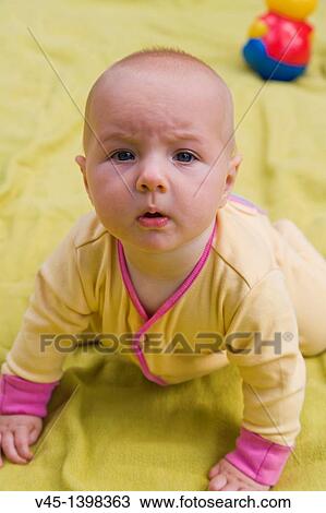 Stock Image - 7 months old baby girl crawling.. Fotosearch