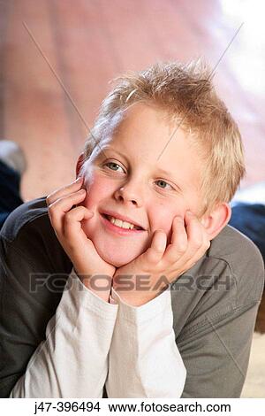 7 year old boy lying on his tummy, head resting on his hand, smiling off camera View Large Photo Image Picture - 7 year old boy lying on his tummy, head resting on his hand, smiling off camera. Fotosearch