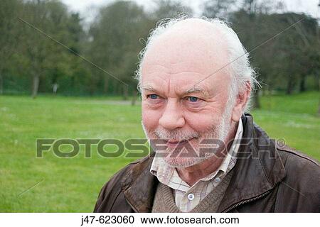 Stock Image - 70 year old man smiling off camera. Fotosearch