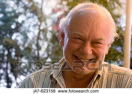 70 Year Old Man With Grey Hair And Beard Smiling Off Camera