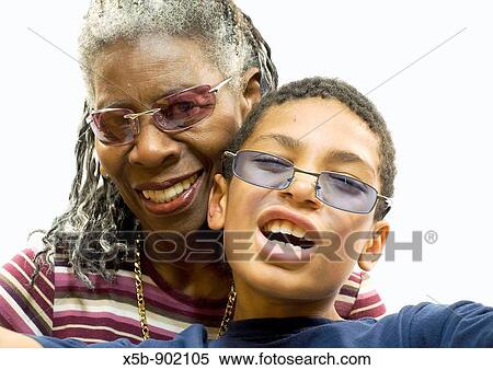 74 year old African American woman with graying dredlocks in her hair 9 year old grandson standing in front The boy is wearing navy blue t-shirt and blue sunglasses Isolated on white Horizontal Both looking towards the camera View Large Photo Image Stock Photography - 74 year old African American woman with graying dredlocks in her hair 9 year old grandson standing in front The boy is wearing navy blue t-shirt and blue sunglasses Isolated on white Horizontal Both looking towards the camera. Fotosearch