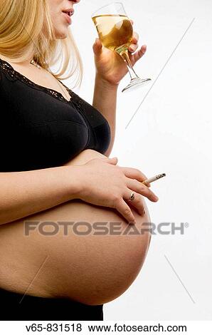 8 1/2 months pregnant woman smoking a cigarette and drinking a glass of white wine View Large Photo Image Stock Photo - 8 1/2 months pregnant woman smoking a cigarette and drinking a glass of white wine. Fotosearch